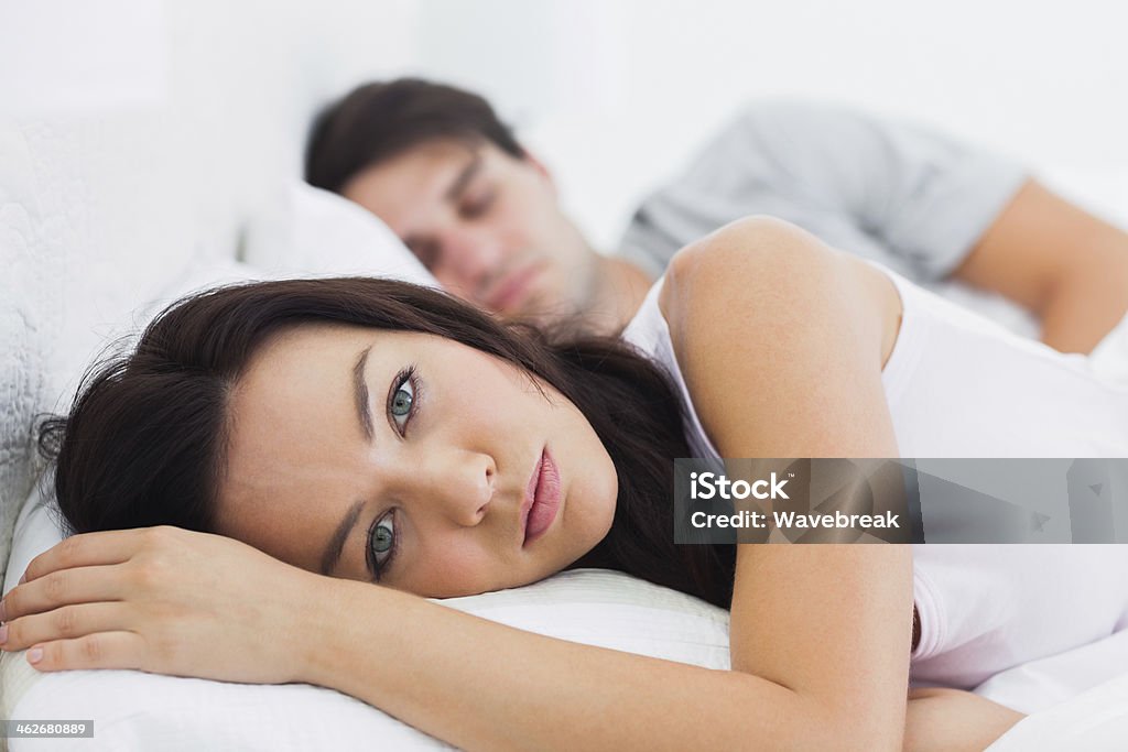 Acordando mulher na cama, ao lado de seu parceiro - Foto de stock de Cama royalty-free