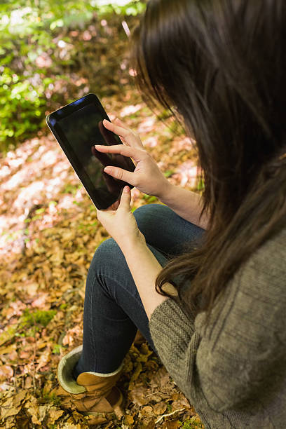 istock Cute woman in green forest using her tablet 462681509
