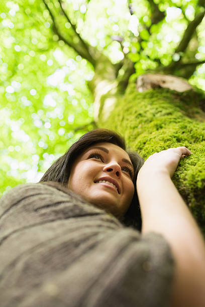 istock Cheerful young woman holding tree trunk 462681551