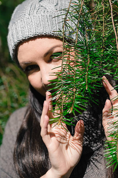 istock Cute woman hiding her face behind a tree branch 462681699