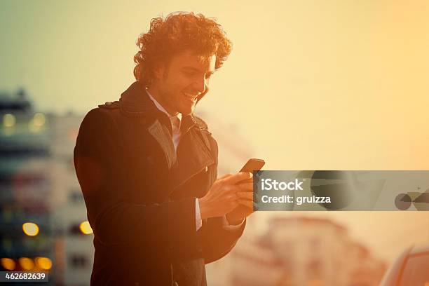Text Messaging On The City Street Stock Photo - Download Image Now - Close-up, Laughing, Men
