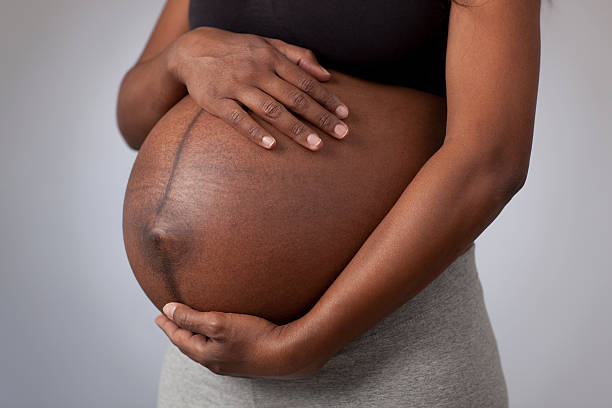 istock Pregnant woman caressing her belly over gray background. 462682893
