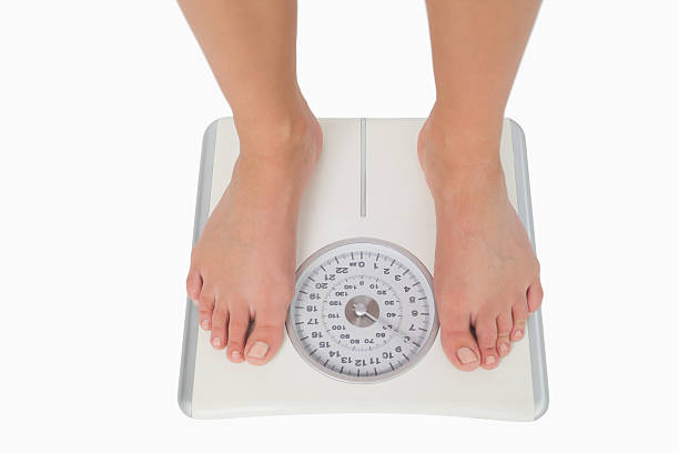 istock Female feet standing on a white scales 462683013
