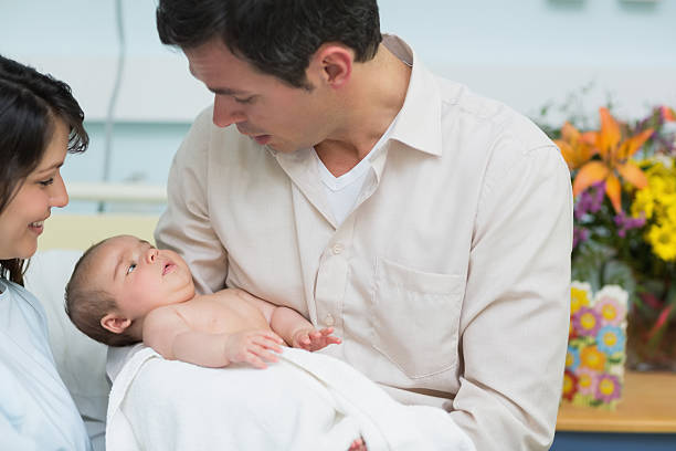 padre sostiene un bebé - hospital flower newborn 40s fotografías e imágenes de stock