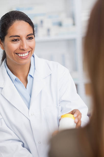 istock Pharmacist smiling and handing drugs to a customer 462697769