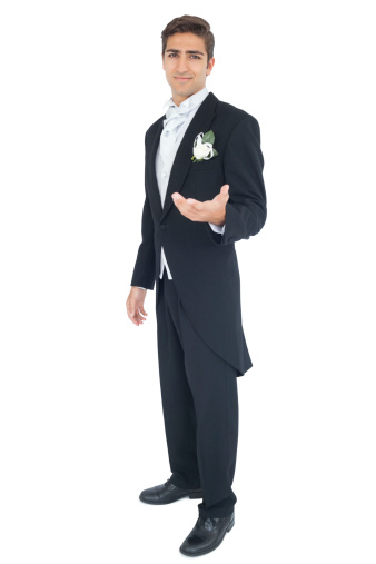 Content attractive young groom presenting his hand on white background