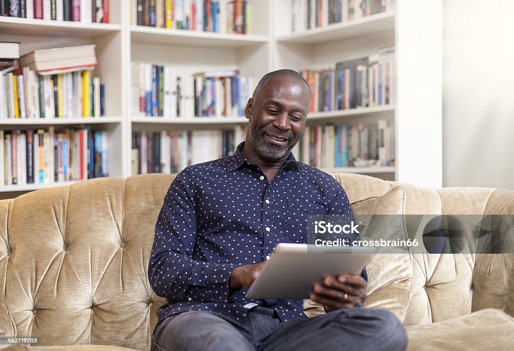 Maturo uomo africano sorridente con digital tablet - Foto stock royalty-free di Uomini