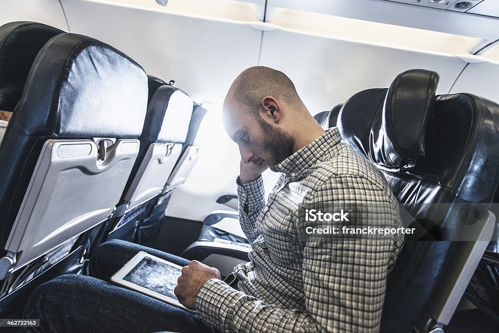Pensive business man using a digital tablet on the plane http://blogtoscano.altervista.org/ob.jpg   30-39 Years Stock Photo