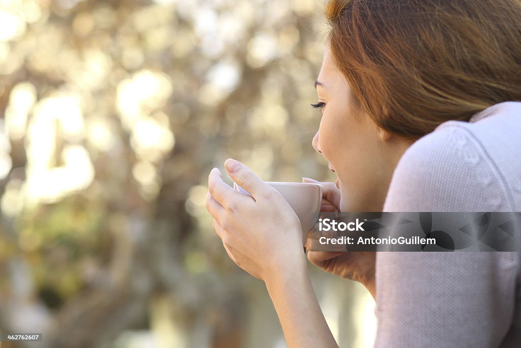 Relaxed woman holding a cup of coffee outdoor Wellness concept of a relaxed woman holding a cup of coffee outdoor Coffee Cup Stock Photo