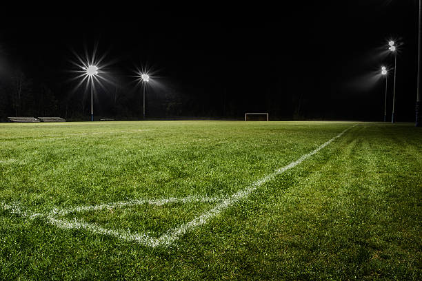 Low view of empty soccer field at night with stadium lights. Soccer field (also called the pitch) under the night time lights stadium playing field grass fifa world cup stock pictures, royalty-free photos & images