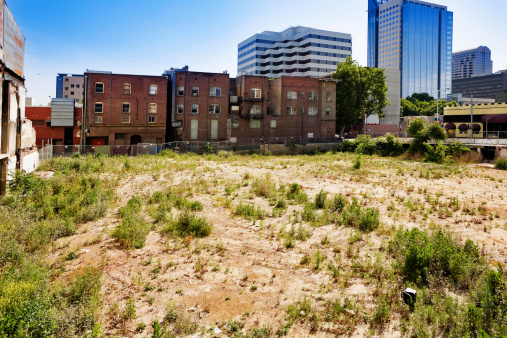 Run down brick buildings and an empty lot in downtown Sacramento, California.