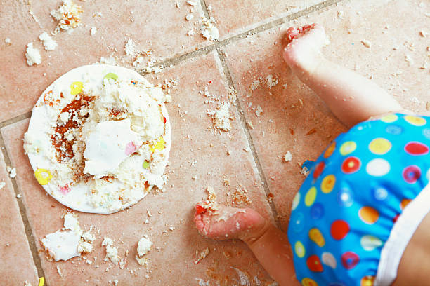 bebê gatinhar afastado de desarrumado bolo de aniversário - baby tile crawling tiled floor imagens e fotografias de stock