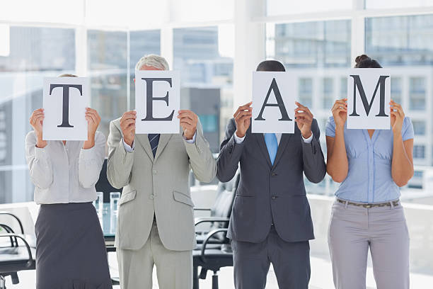 istock Business people showing pages spelling team 462779859