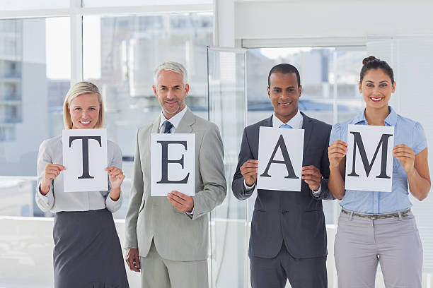 istock Business people holding up pages spelling team 462779863