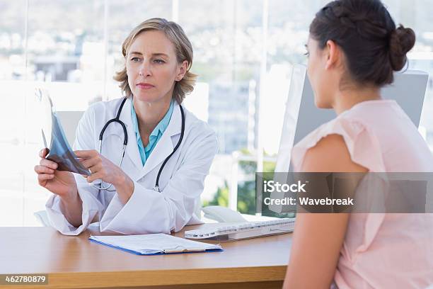 Doctor Showing A X Ray To Her Patient Stock Photo - Download Image Now - 20-29 Years, 40-49 Years, Adult