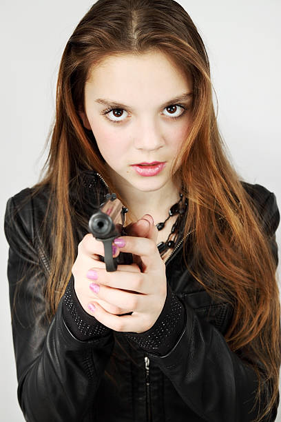 girl holding a gun Young beautiful girl holds in the hand the weapon baby gun stock pictures, royalty-free photos & images