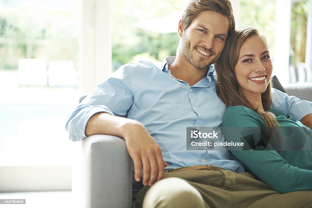 Sorrindo Jovem casal relaxando no sofá - Foto de stock de Casal Jovem royalty-free