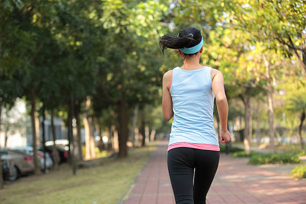 istock woman morning exercise jogging at park 462795093