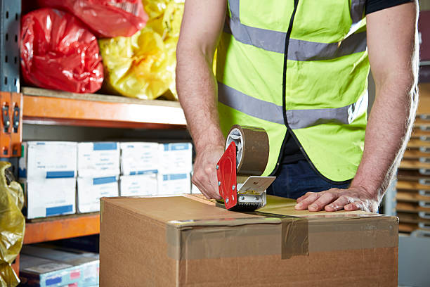 istock Man sealing box with tape 462798387