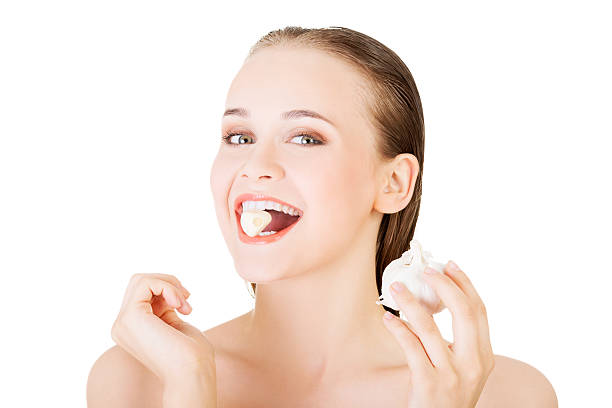 istock Young beautiful woman eating garlic. 462802195