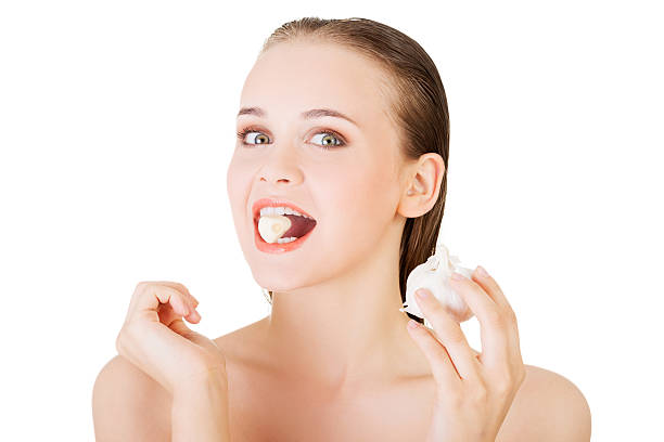 istock Young beautiful woman eating garlic. 462802207