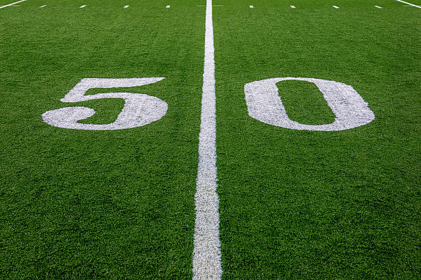 The 50 Yard Line The 50 yard line in a football field. offensive line stock pictures, royalty-free photos & images