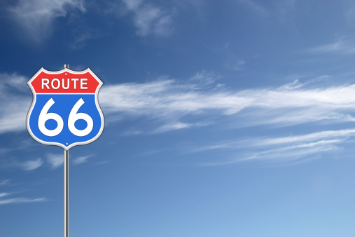 Red and blue Route 66 Road Sign isolated on blue sky background.