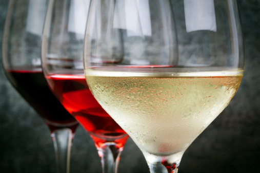 Glasses of white, rose and red wine.  Focus on foreground.