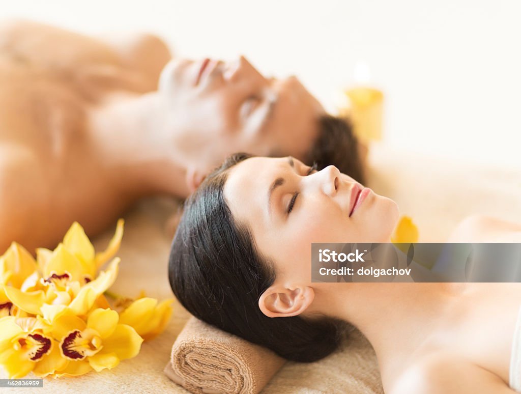 A close up of a couple relaxing at a day spa picture of couple in spa salon lying on the massage desks Couple - Relationship Stock Photo