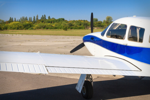 Walking small propeller plane on a green field