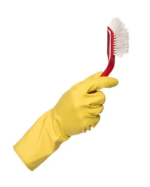 Yellow protection glove holding a dishbrush isolated on white background