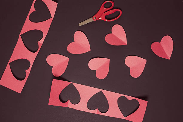 istock Making Cutout Hearts, Red paper hearts and scissors 462858297