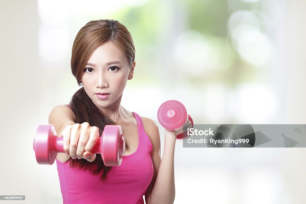 Young sport girl with dumbbells Young sport girl with dumbbells with green background, asian Adult Stock Photo