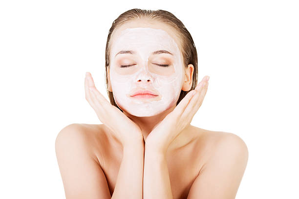 Beautiful woman with clay facial mask stock photo