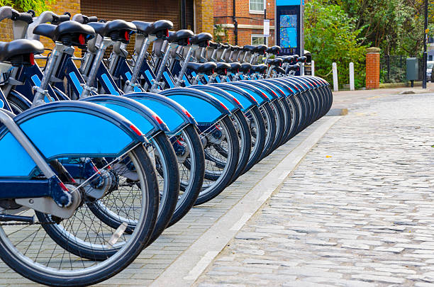 City bicycles aligned at docking station in London, England Bikes for Rent, London. - Stock Image, Bikes for rent in London. ( introduced in July 2010 across London) bicycle docking station stock pictures, royalty-free photos & images