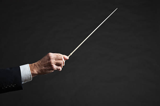 istock A conductor holding the wand to construct an orchestra 462863323