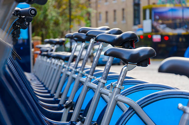 London with bicycles docks stations, England London Hire Bikes - Stock Image. A row of hire bikes lined up in a docking bay in London. Bikes introduced in July 2010 across London aiming to reduce traffic across the city and introduce an environmentally friendly form of transport. bicycle docking station stock pictures, royalty-free photos & images