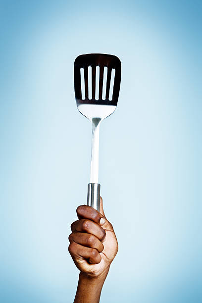 istock Single hand holds up egg lifter/turner triumphantly 462866559