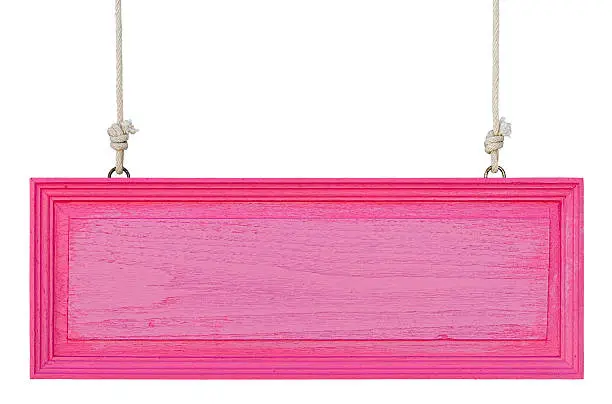 Old weathered pink/purple wood signboard, hanging by old rope, isolated on white, clipping path included.