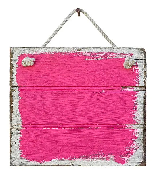 Old weathered pink/purple wood signboard, hanging by old rope from a nail, isolated on white, clipping path included.