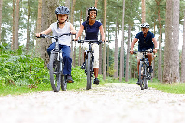 glückliche junge familie reiten fahrräder - wildnisgebiets name stock-fotos und bilder