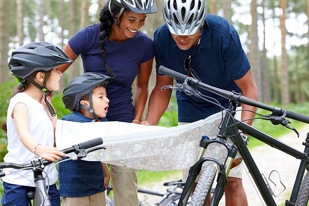 istock Family with bicycles reading a map for direction in forest 462870647