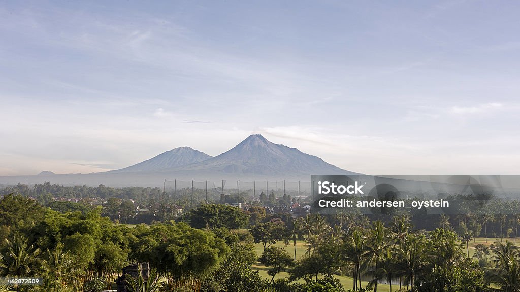 Merapi and Merbabu Volcano, Indonesia Merapi and Merbabu Volcano volcano is located on Central-Java, Indonesia. Close to the city of Yogyakarta. Merbabu is the peak located left and Merapi on the right. Ash Tree Stock Photo