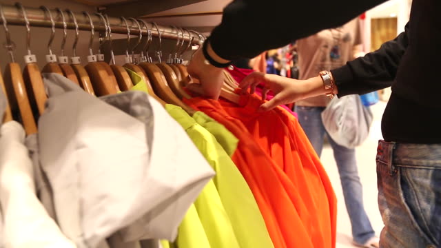 HD:Woman selecting items in a clothes shop.