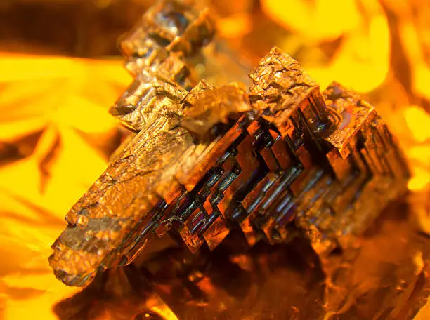 a multicolored Bismuth crystal, warm illuminated in golden back
