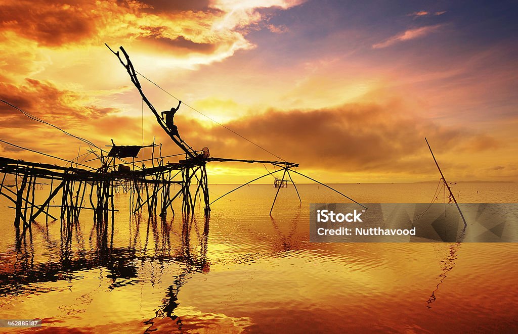 Fisherman silhouette on fishnets Activity Stock Photo