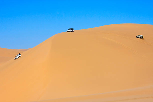 istock 4x4 off road vehicles driving across the sand dunes, Namibia. 462885291