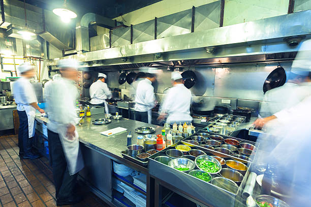 Chefs Working Busily in Chinese Kitchen stock photo