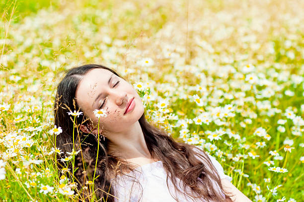 istock woman with closed eyes relaxes in daisies 462910309