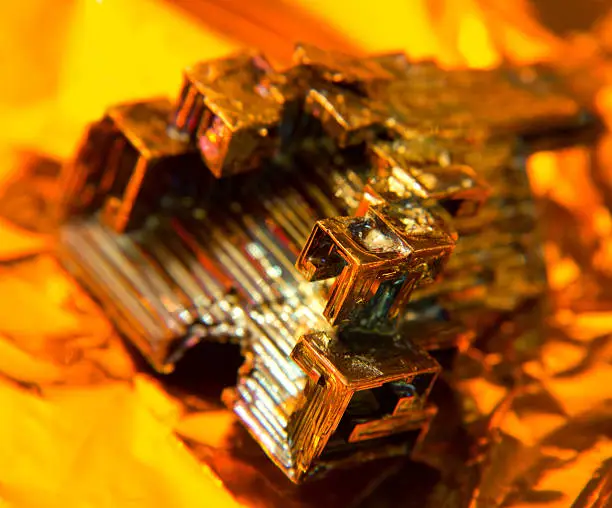 a multicolored Bismuth crystal, warm illuminated in golden back